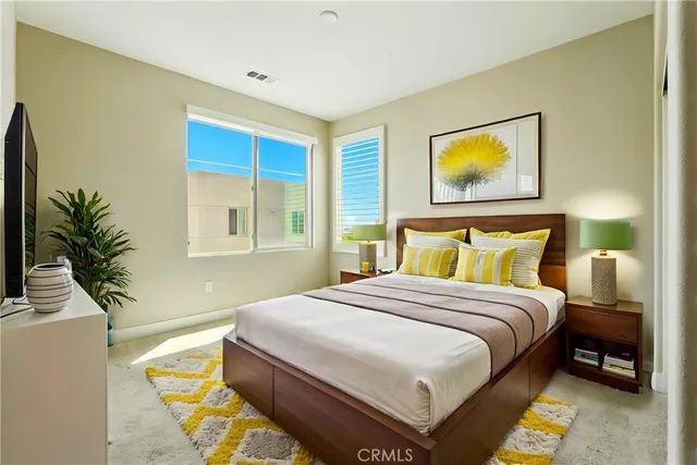 a bedroom with a bed and a potted plant