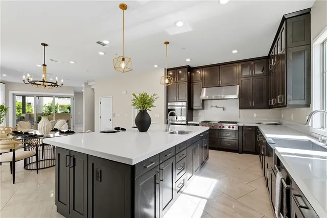a kitchen with a stove a sink a kitchen island with chairs and wooden floor