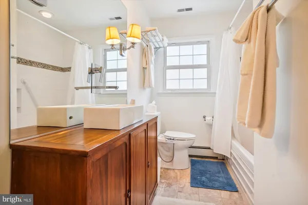 a bathroom with a sink a toilet and a window
