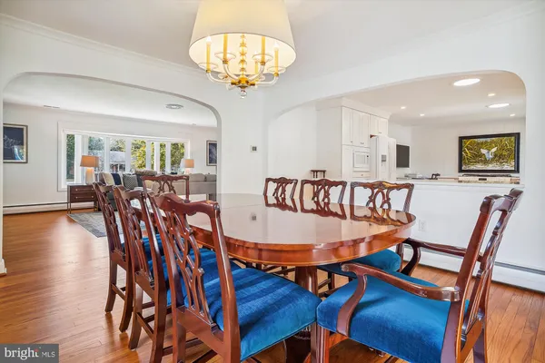 a dining room with furniture a chandelier and wooden floor
