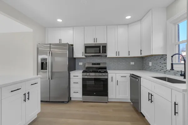 a kitchen with cabinets stainless steel appliances and a counter space