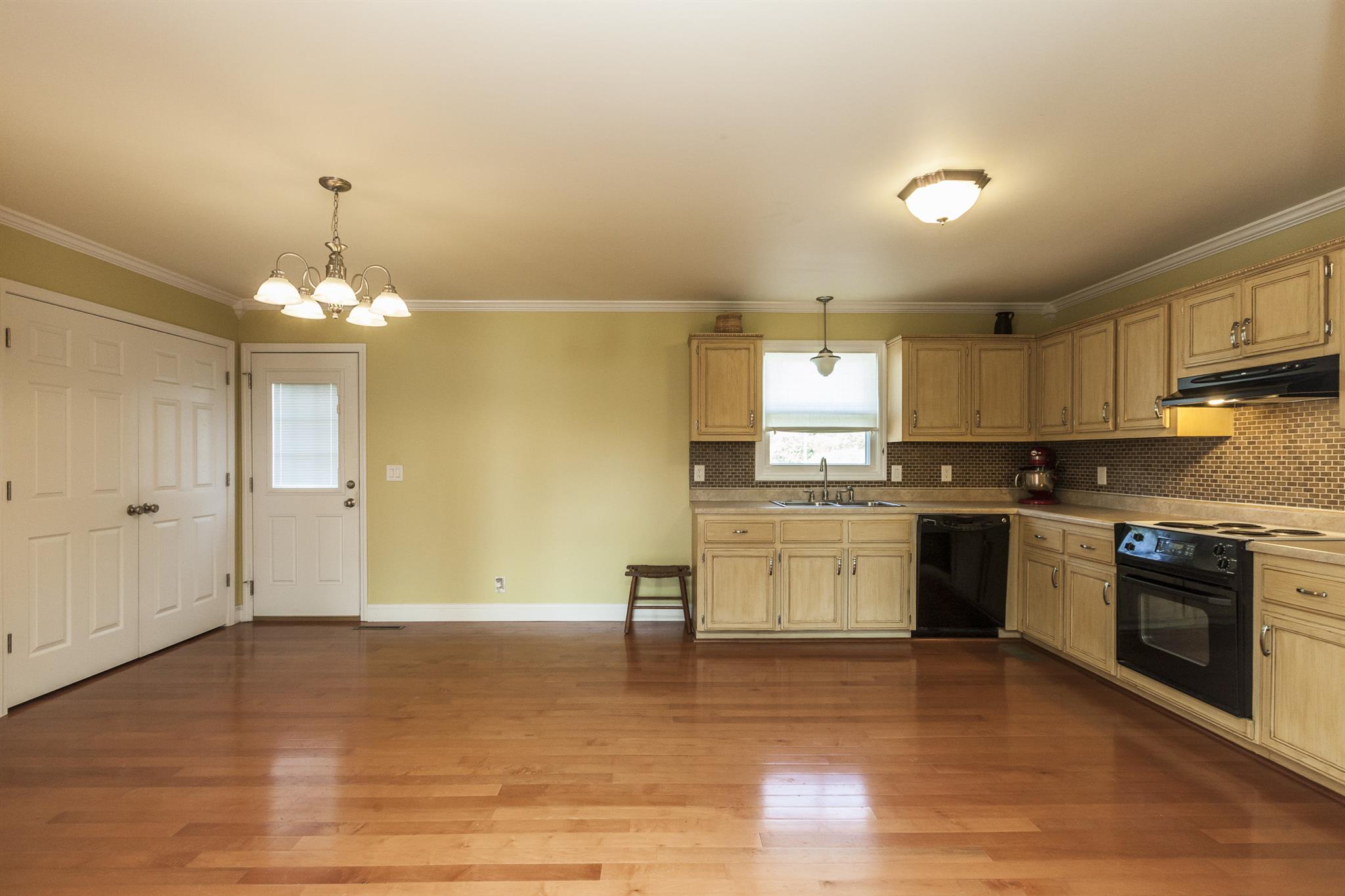 2730 West County Farm Road Springfield, TN 37172 - Photo 11 of 22 a large kitchen with granite countertop a stove top oven a sink dishwasher and white cabinets with wooden floor
