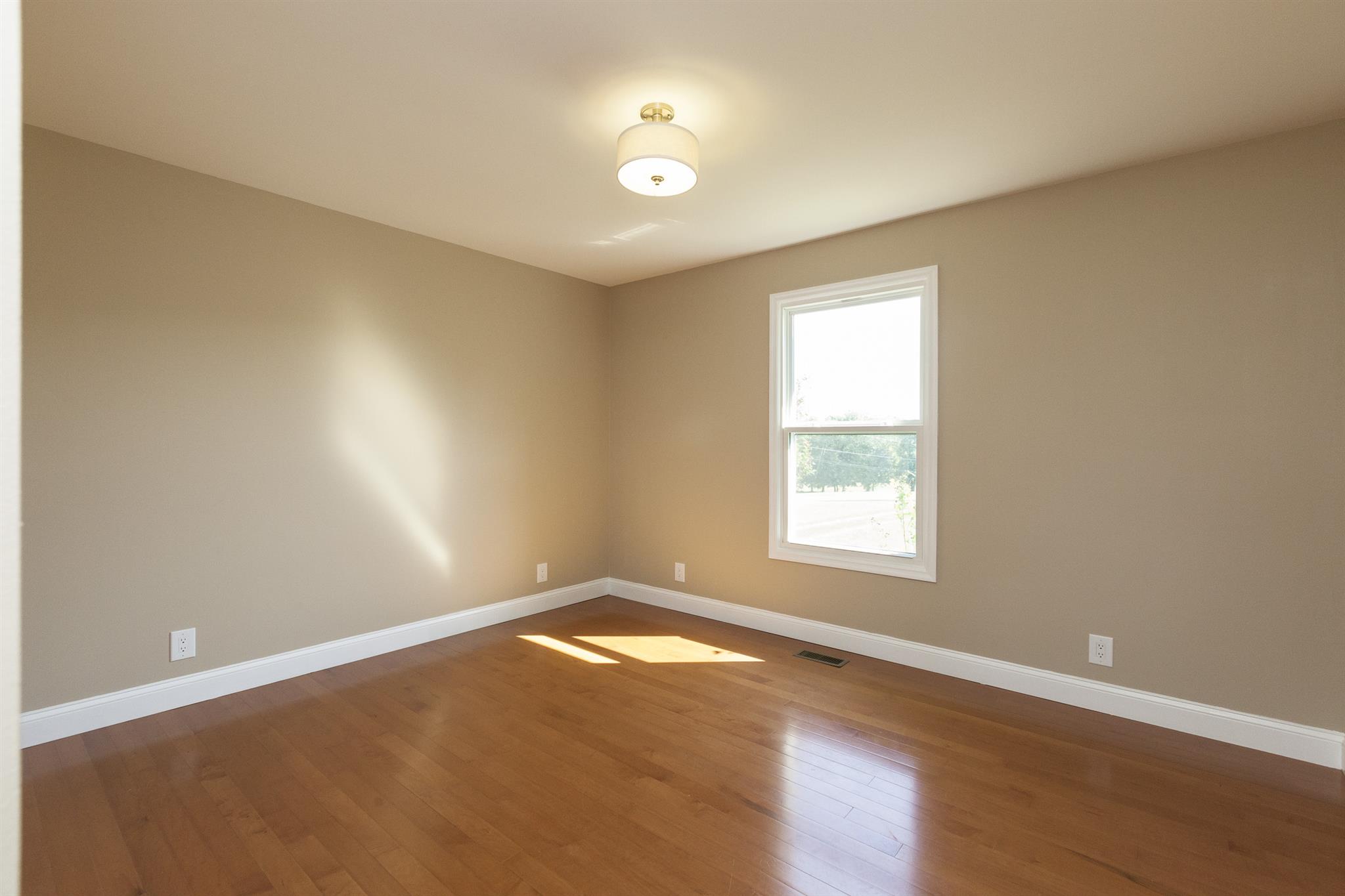 2730 West County Farm Road Springfield, TN 37172 - Photo 18 of 22 an empty room with wooden floor and windows