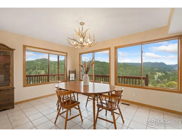 a dining room with furniture large windows and a chandelier