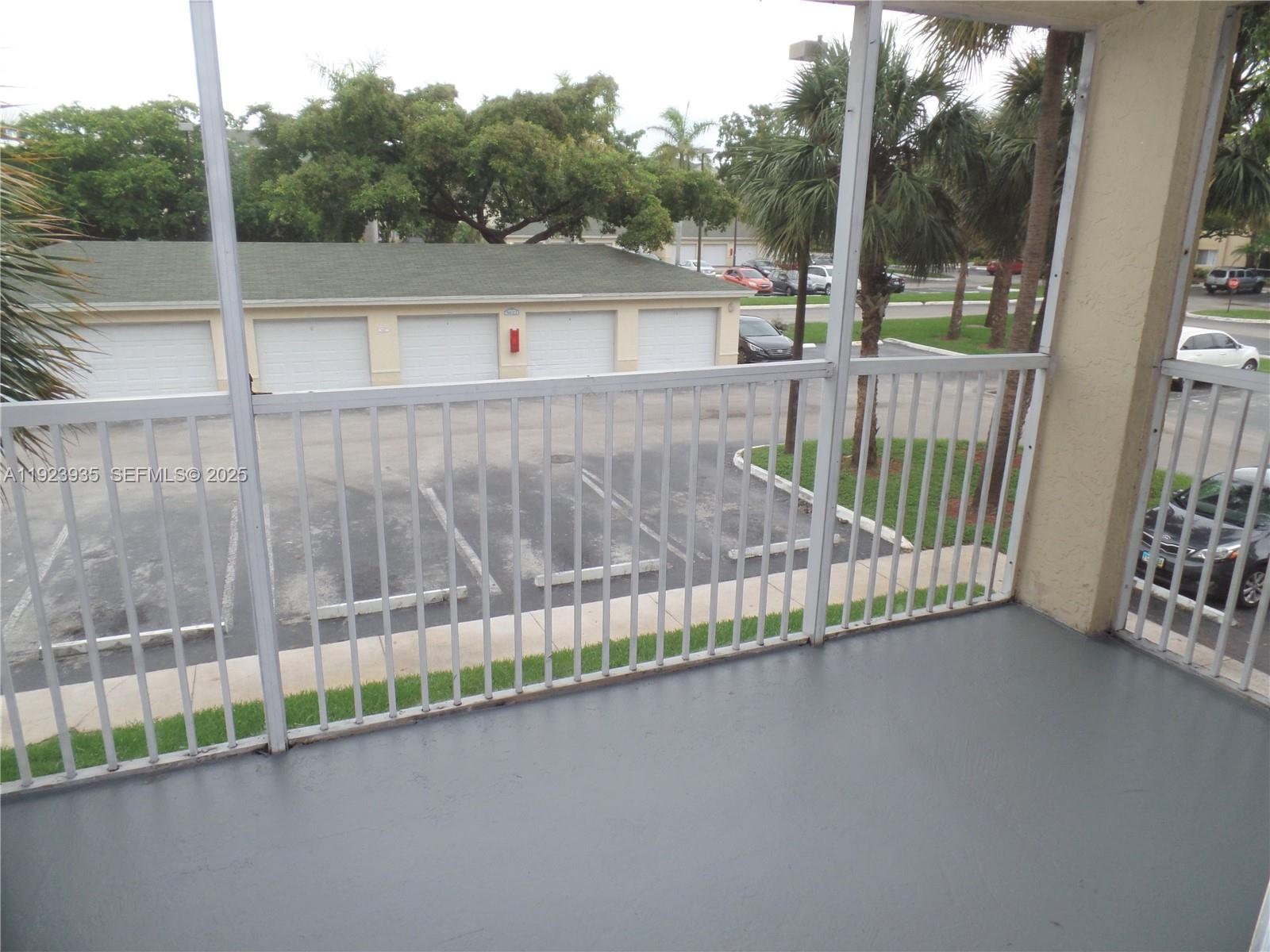 5612 Rock Island Road, Unit 151 Tamarac, FL 33319 - Photo 21 of 26 a view of a balcony with a floor to ceiling window and wooden floor