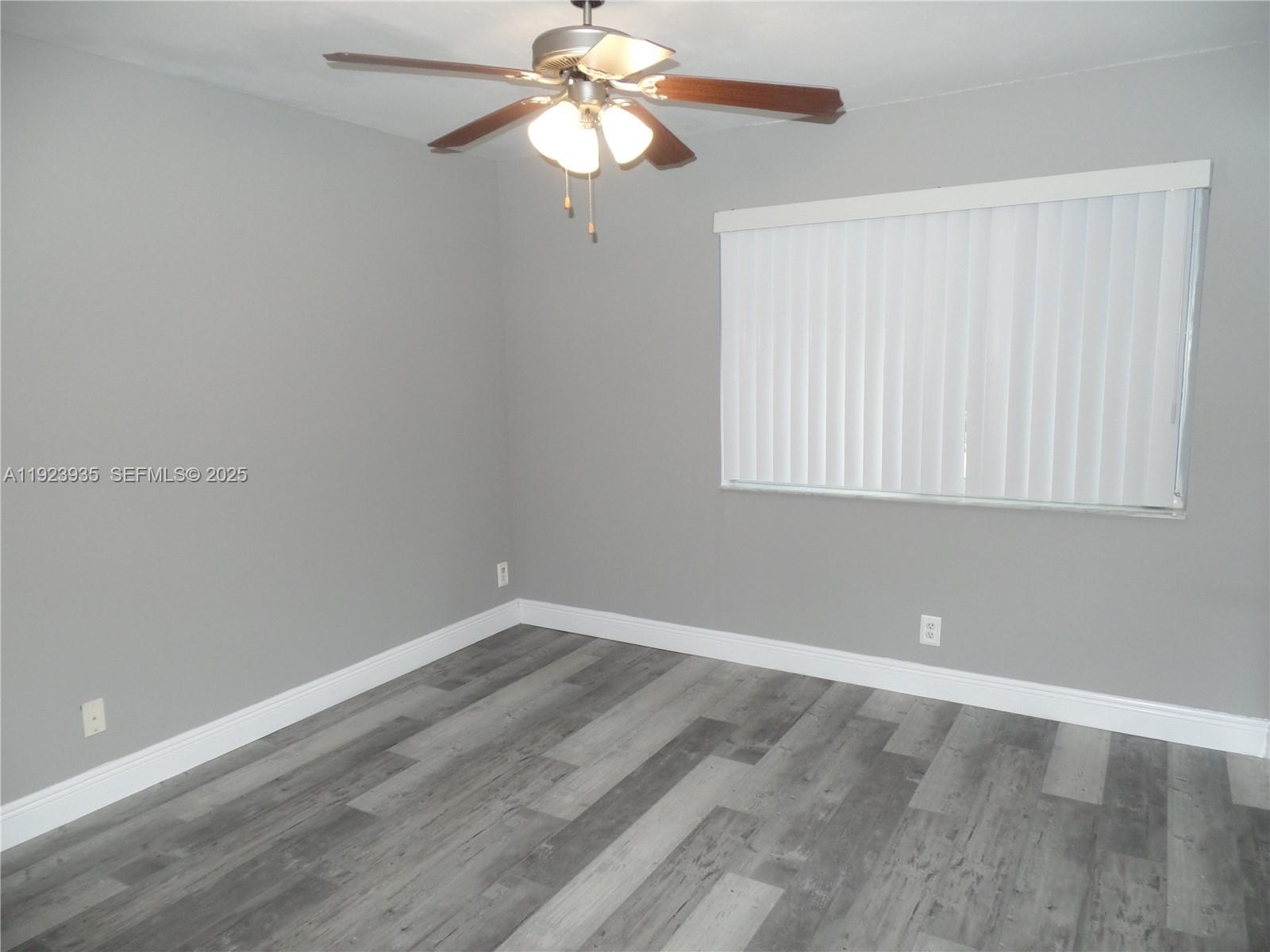 5612 Rock Island Road, Unit 151 Tamarac, FL 33319 - Photo 8 of 26 wooden floor in an empty room with a window