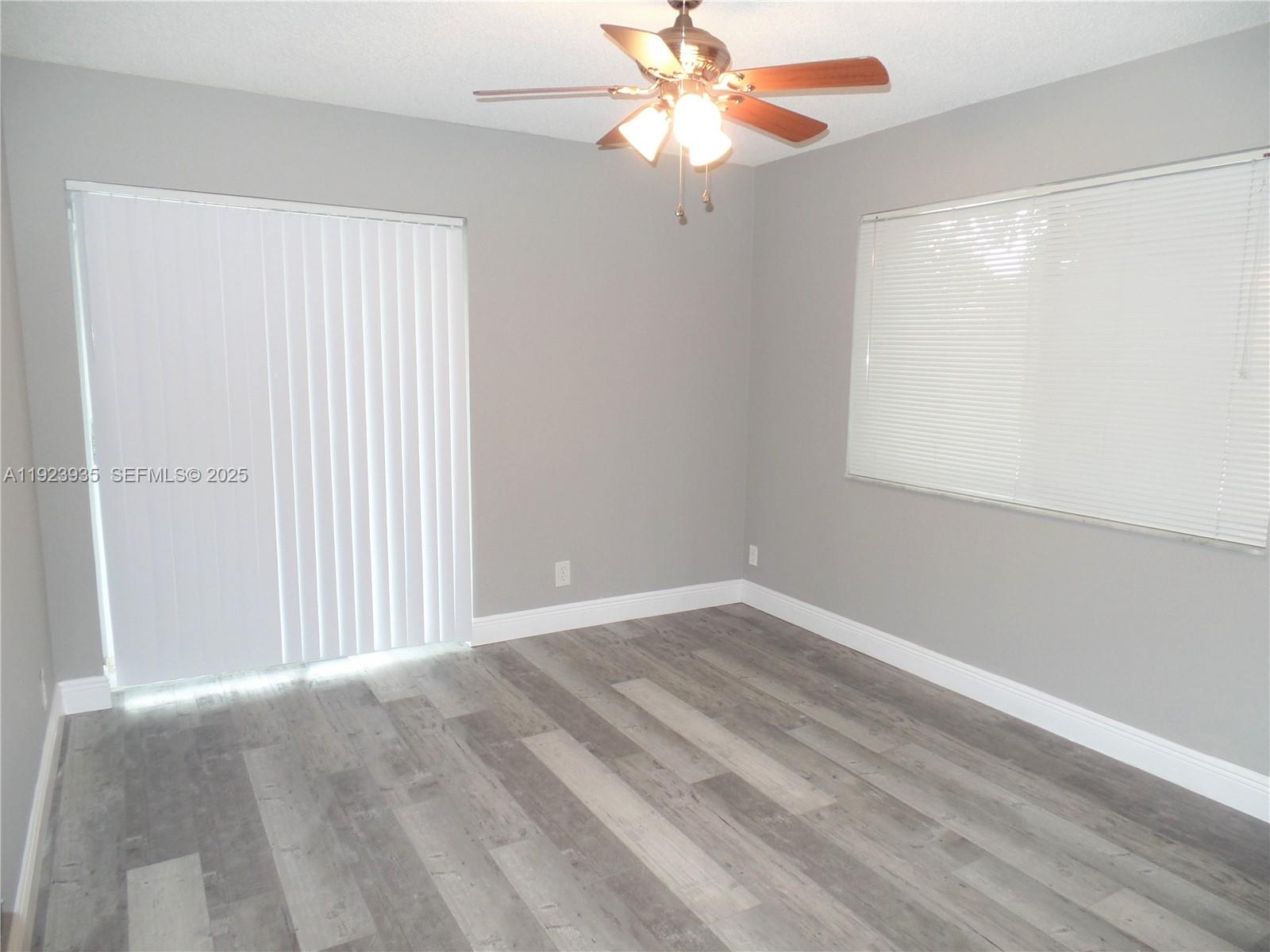 5612 Rock Island Road, Unit 151 Tamarac, FL 33319 - Photo 9 of 26 an empty room with windows and fan