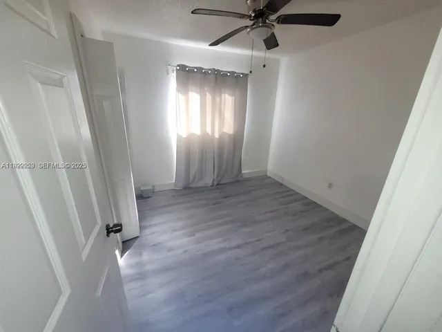 a kitchen with granite countertop a refrigerator a sink and wooden floor
