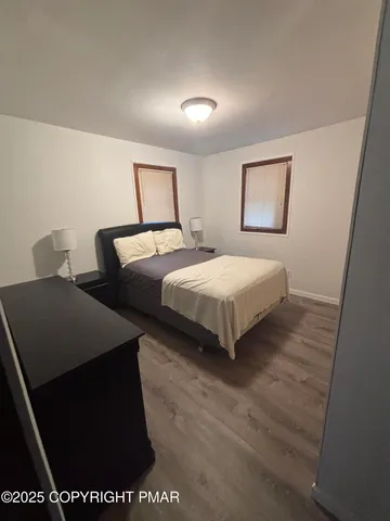 a bedroom with two beds and a painting on the wall