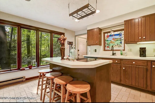 a view of a kitchen area with furniture and large windows