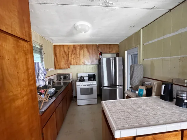 a kitchen with stainless steel appliances granite countertop a refrigerator oven a sink and dishwasher