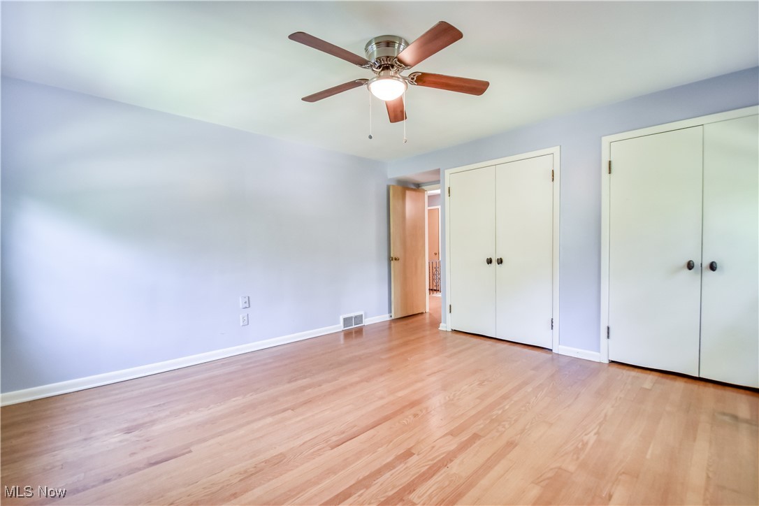 2607 Ashurst Road University Heights, OH 44118 - Photo 34 of 39 Unfurnished bedroom featuring two closets, light wood finished floors, and a ceiling fan