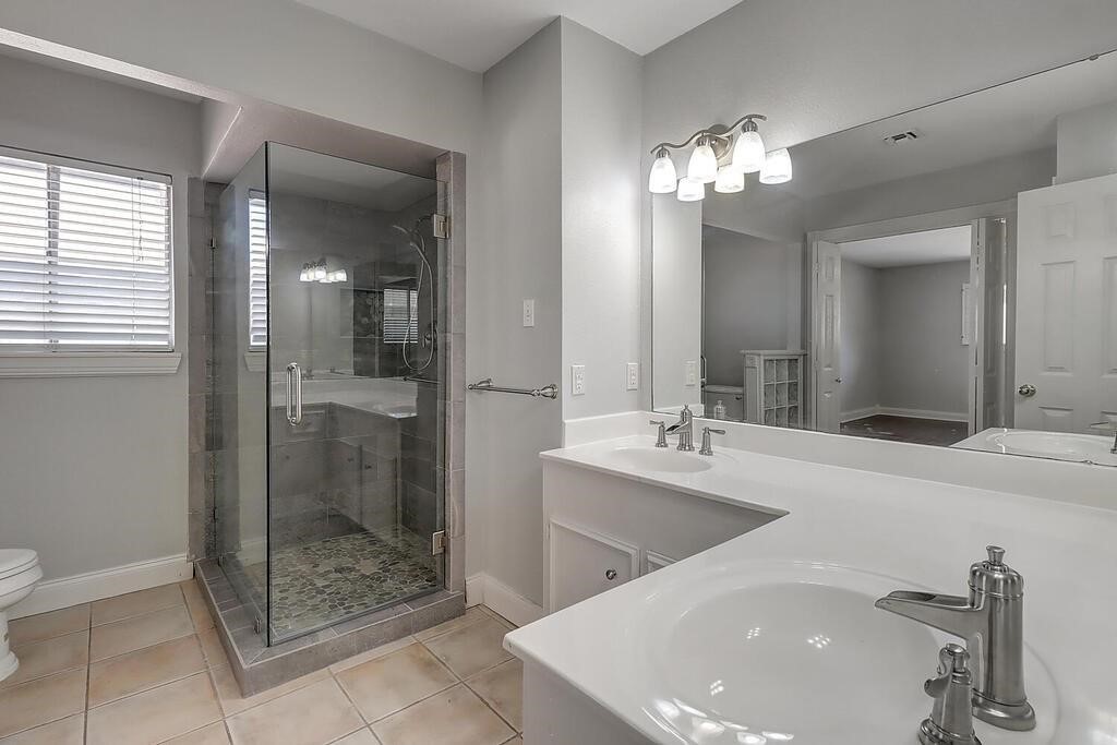 6426 Long Circle Corpus Christi, TX 78413 - Photo 12 of 40 a spacious bathroom with a shower a sink and mirror