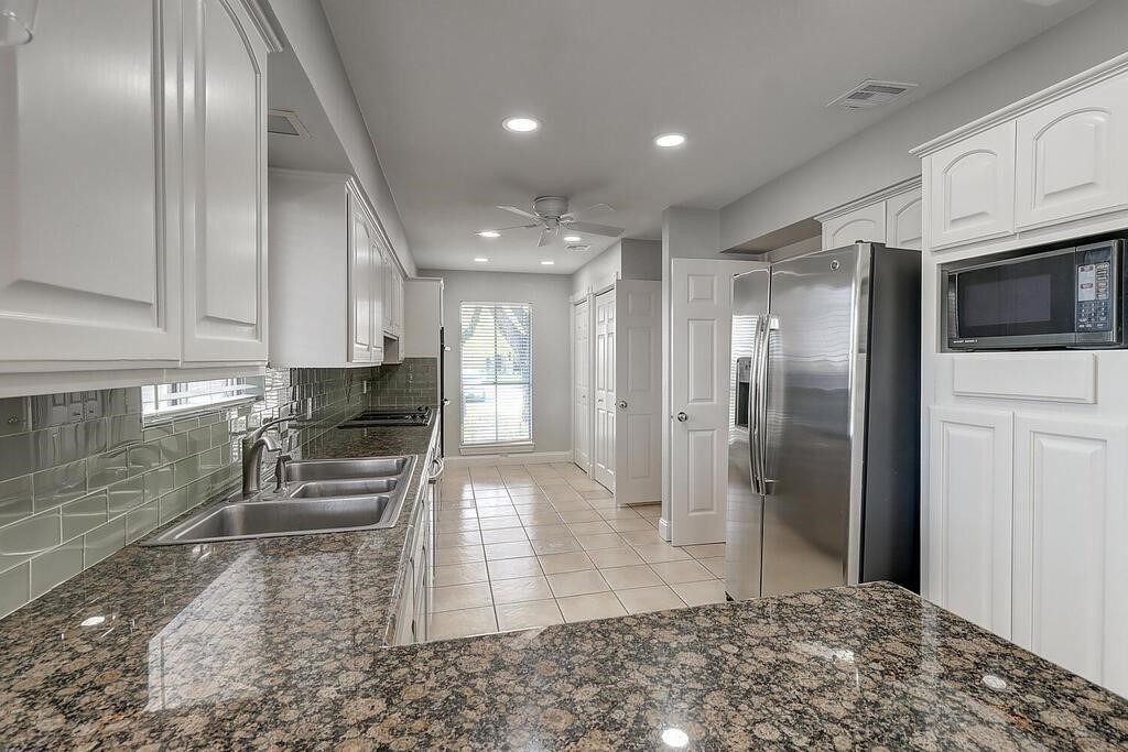 6426 Long Circle Corpus Christi, TX 78413 - Photo 15 of 40 a kitchen with stainless steel appliances kitchen island granite countertop a refrigerator and a sink