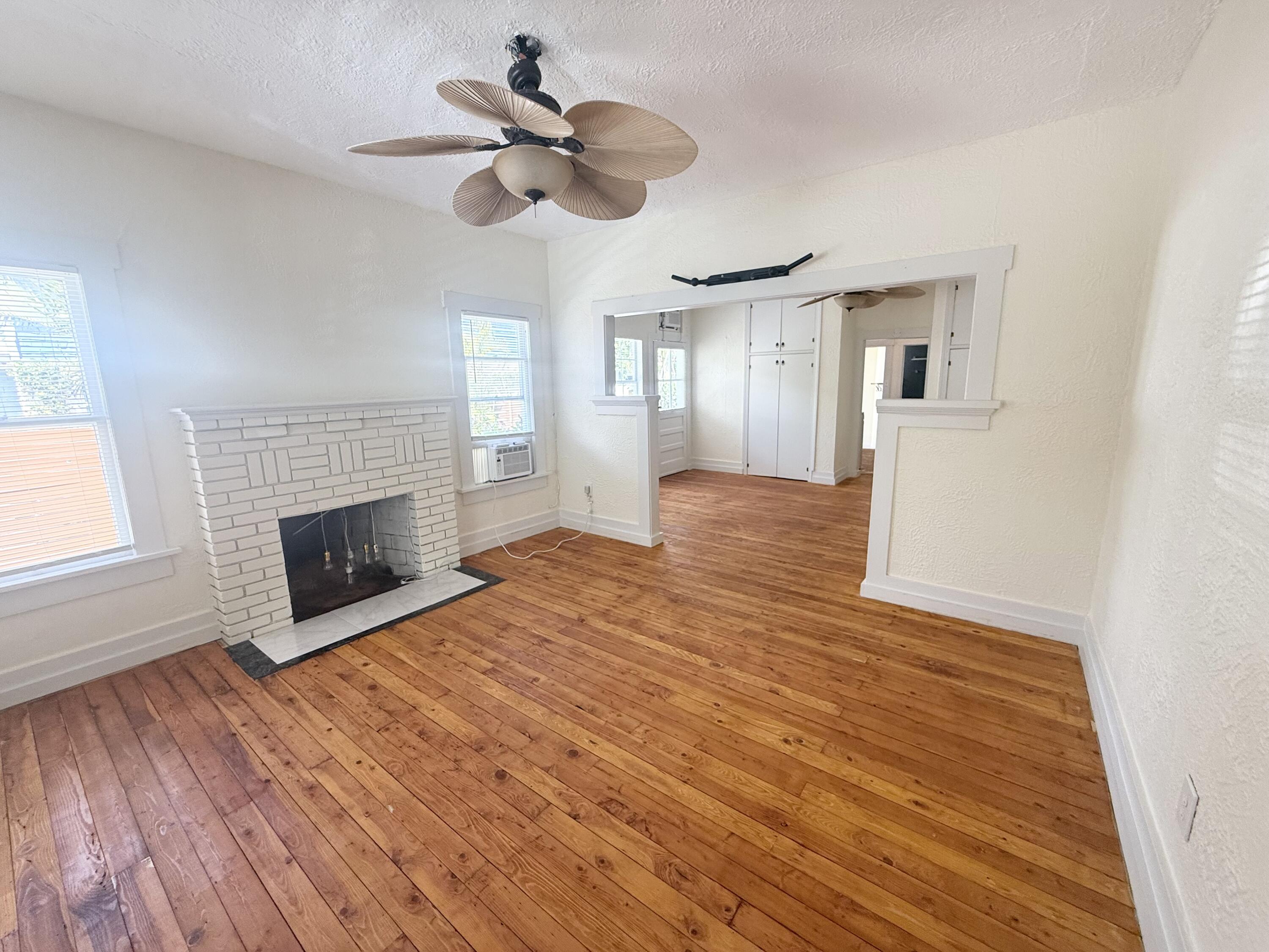 311 Wildermere Road West Palm Beach, FL 33401 - Photo 19 of 87 a view of a livingroom with a fireplace a ceiling fan and wooden floor