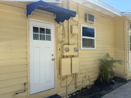 a view of an empty room with wooden floor fireplace and a window