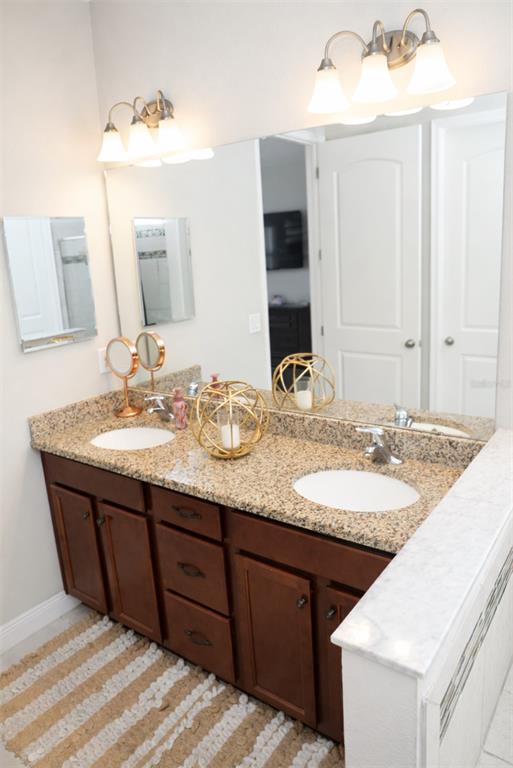1216 Old Windsor Way Spring Hill, FL 34609 - Photo 11 of 31 a bathroom with a granite countertop sink and a mirror