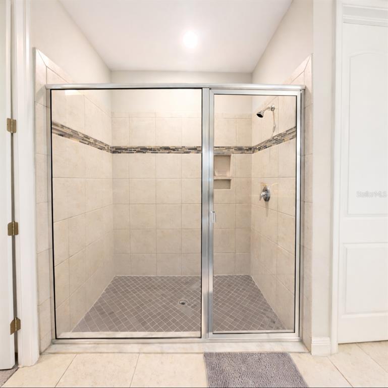 1216 Old Windsor Way Spring Hill, FL 34609 - Photo 15 of 31 a bathroom with a glass shower door