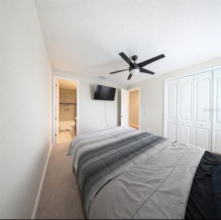 1216 Old Windsor Way Spring Hill, FL 34609 - Photo 25 of 31 a bedroom with a large bed and a ceiling fan