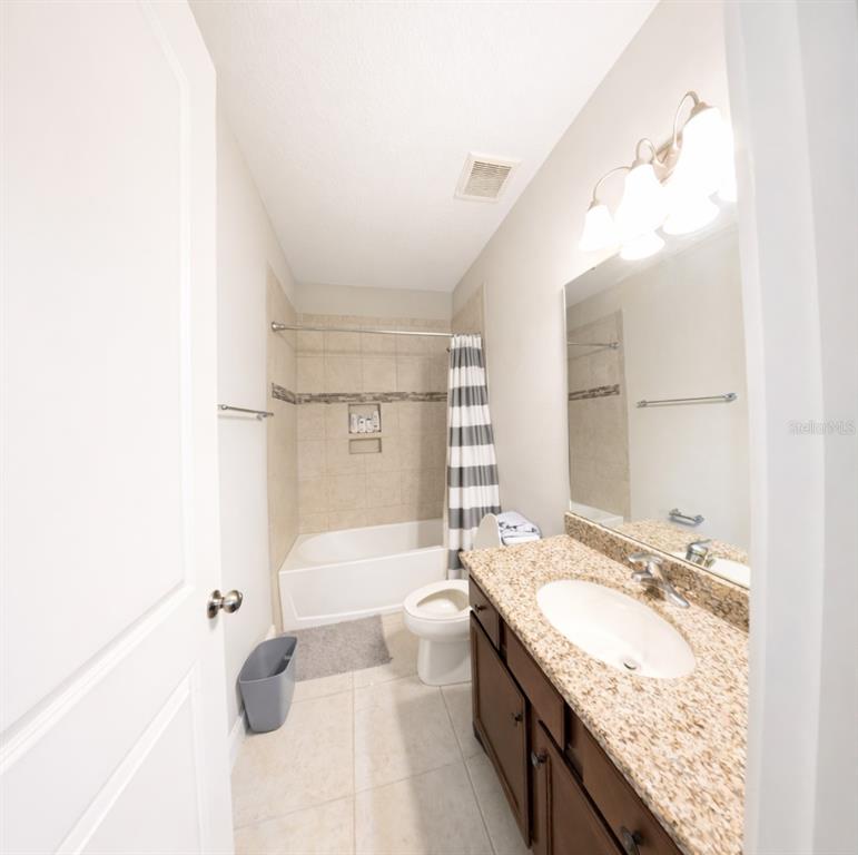 1216 Old Windsor Way Spring Hill, FL 34609 - Photo 27 of 31 a bathroom with a granite countertop sink a toilet a mirror and bathtub