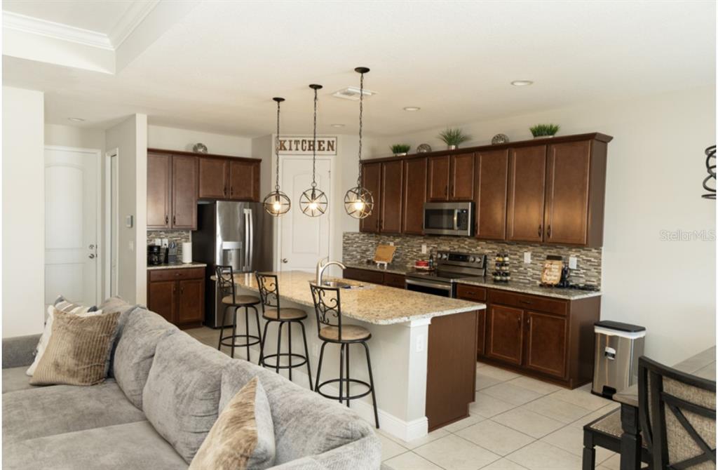 1216 Old Windsor Way Spring Hill, FL 34609 - Photo 8 of 31 a kitchen with stainless steel appliances granite countertop a stove top oven a refrigerator a sink and dishwasher