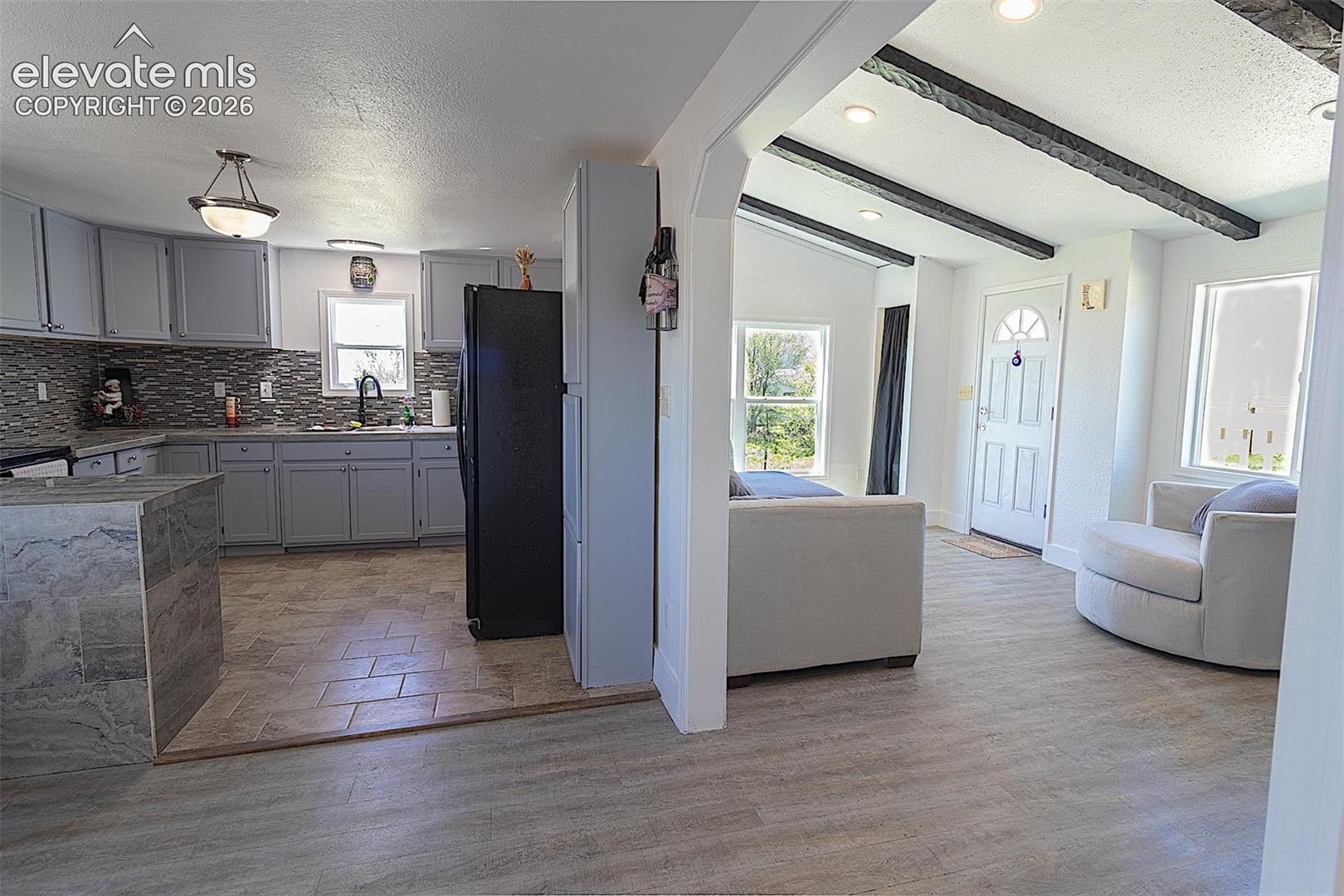 3425 Wiesner Road Calhan, CO 80808 - Photo 6 of 25 Kitchen with freestanding refrigerator, healthy amount of natural light, backsplash, gray cabinets, and a textured ceiling