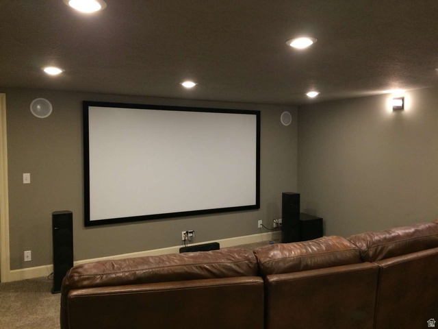 7030 West 2100 North Mendon, UT 84325 - Photo 62 of 67 Dedicated media room featuring a large projection screen, recessed ceiling lighting, wall-mounted speakers, and sconce lighting
