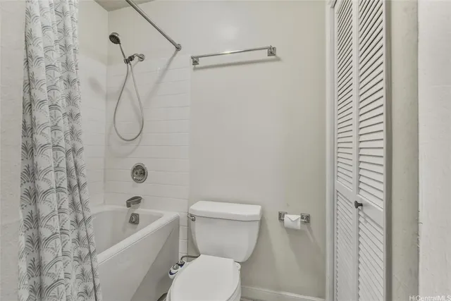 a white toilet sitting next to a bath tub