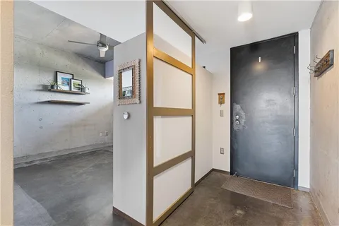 an empty room with windows and ceiling fan