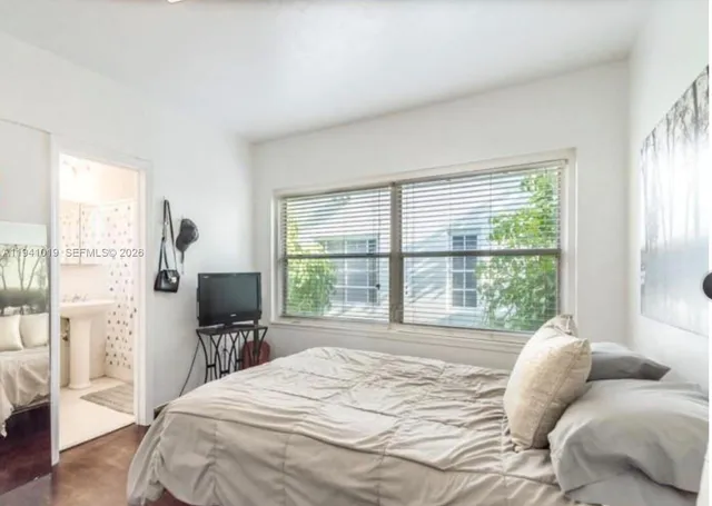 a bedroom with a bed and a large window