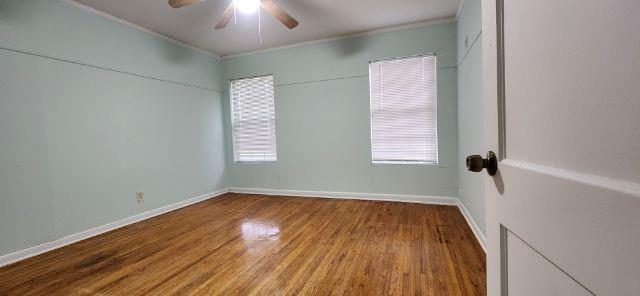 108 East Maple Street Keene, TX 76059 - Photo 7 of 14 an empty room with wooden floor and windows