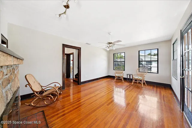 a view of a room with wooden floor air conditioner and windows