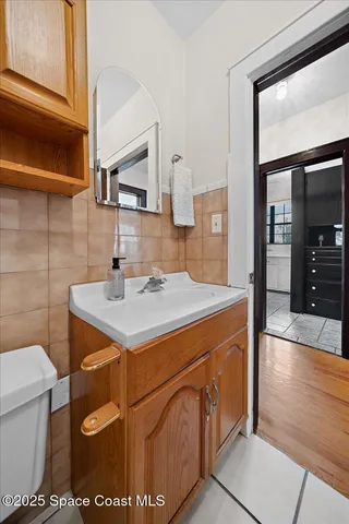 a kitchen with a sink and a stove with wooden floor