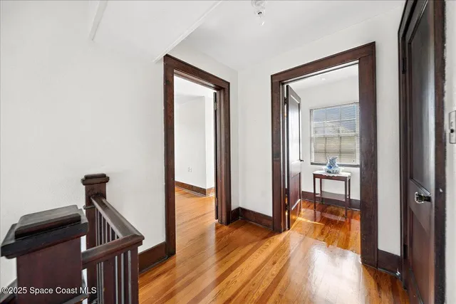 a view of a hallway to a livingroom with furniture and wooden floor