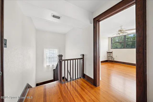 a view of a room with wooden floor and a window