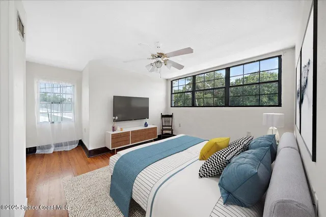 a bedroom with a bed and wooden floor