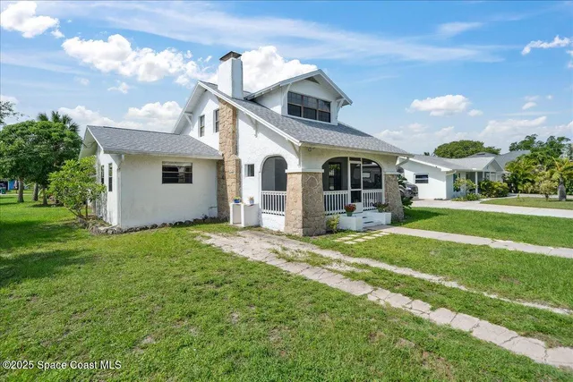 a front view of a house with a garden and yard