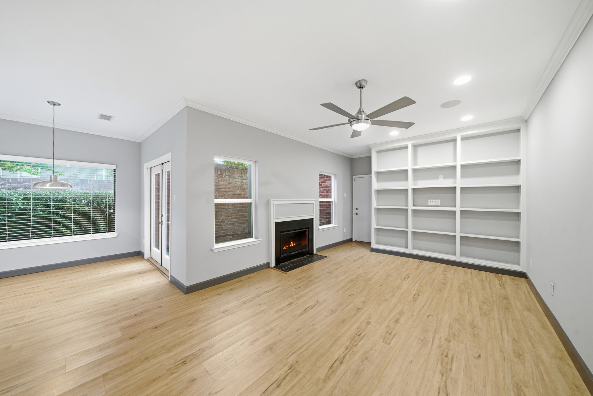 7447 Cambridge Street, Unit 65 Houston, TX 77054 - Photo 12 of 42 an empty room with fireplace wooden floor and windows