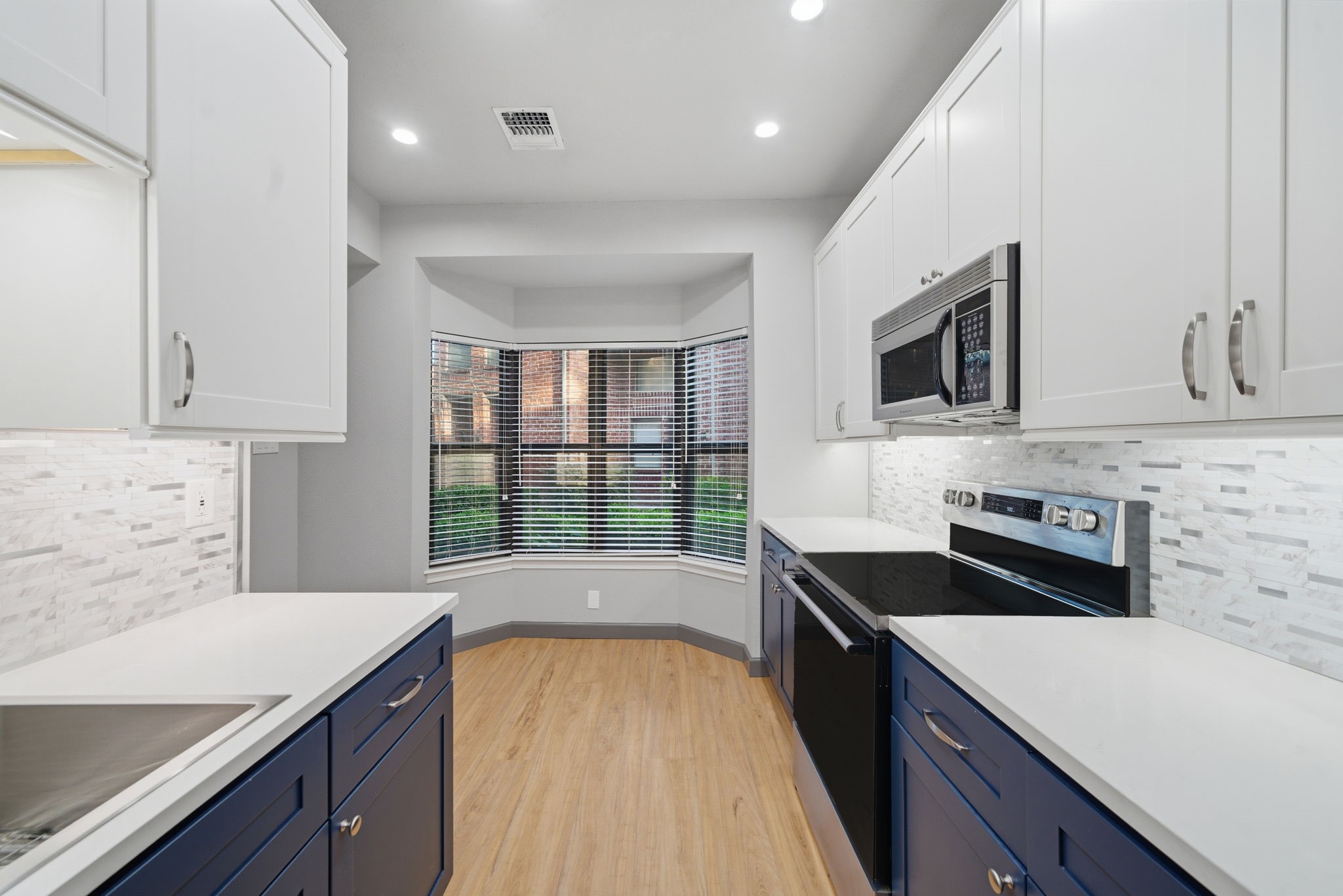 7447 Cambridge Street, Unit 65 Houston, TX 77054 - Photo 16 of 42 a kitchen with a stove a sink and a microwave