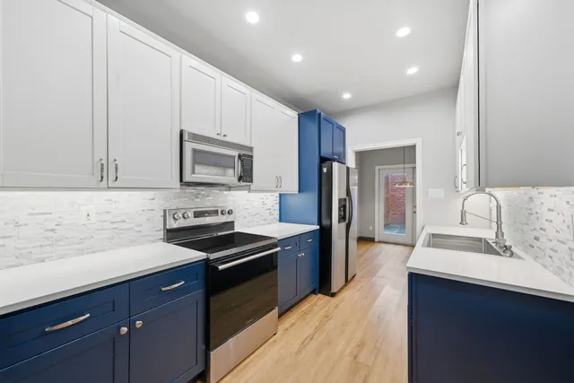 a kitchen with stainless steel appliances granite countertop a stove a refrigerator and a microwave