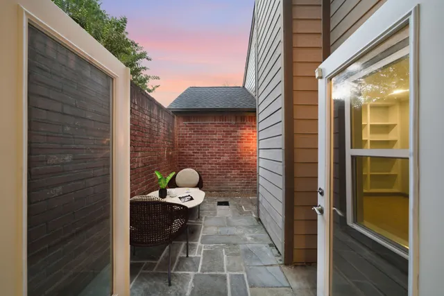 a view of a house with a small yard and a large parking space