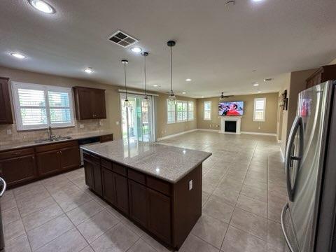 1749 Ettle Street Manteca, CA 95337 - Photo 4 of 12 a kitchen with granite countertop a sink a counter top space stainless steel appliances and a window