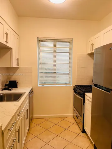 a kitchen with granite countertop a refrigerator and a sink
