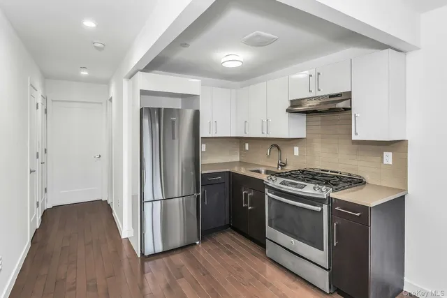 a kitchen with stainless steel appliances a stove a refrigerator and a sink