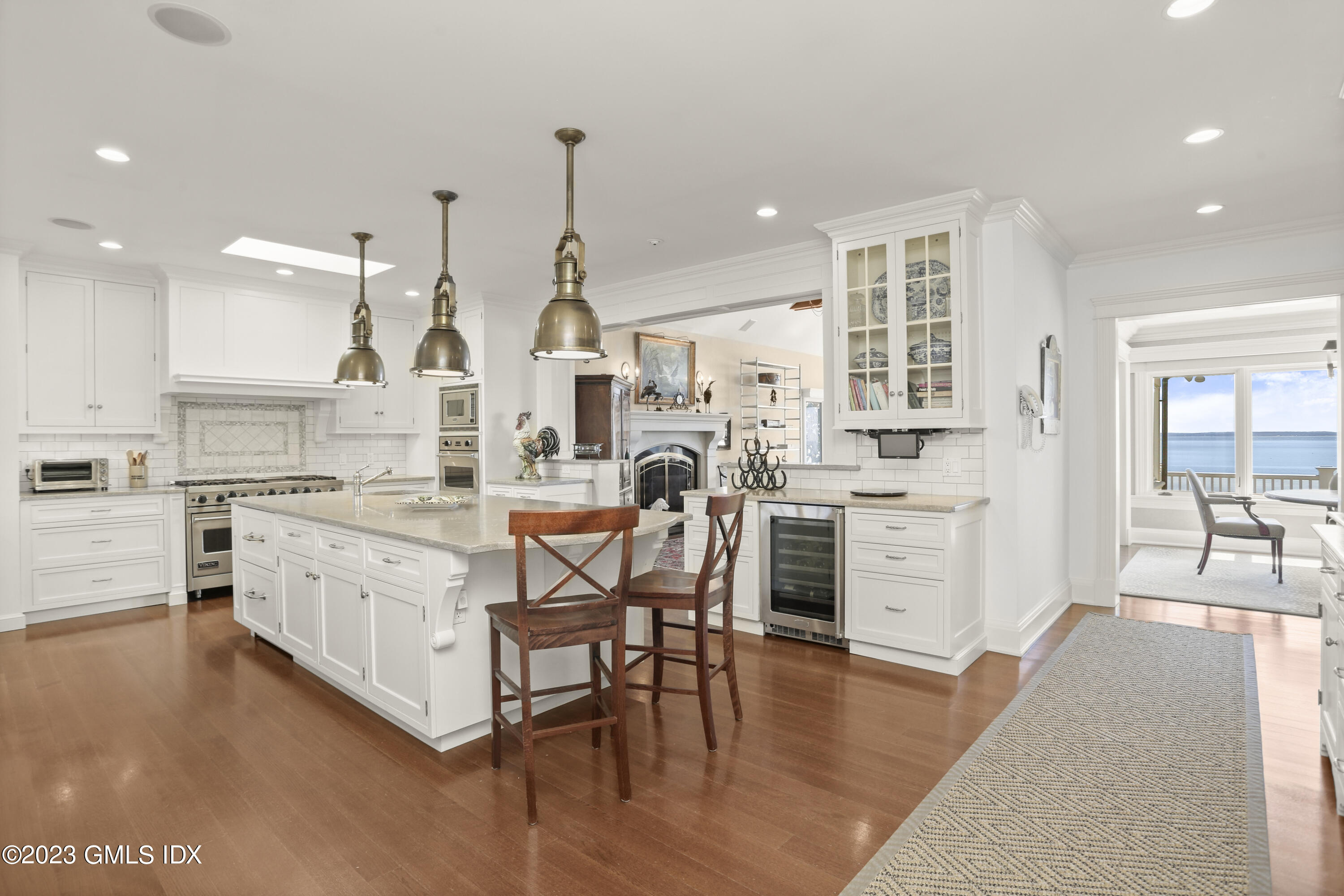 18 Pilot Rock Lane Riverside, CT 06878 - Photo 12 of 50 a kitchen with stainless steel appliances kitchen island granite countertop a table chairs stove and white cabinets