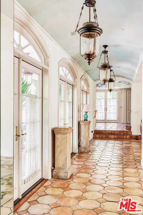 527 North Maple Drive Beverly Hills, CA 90210 - Photo 24 of 54 a view of a hallway with windows