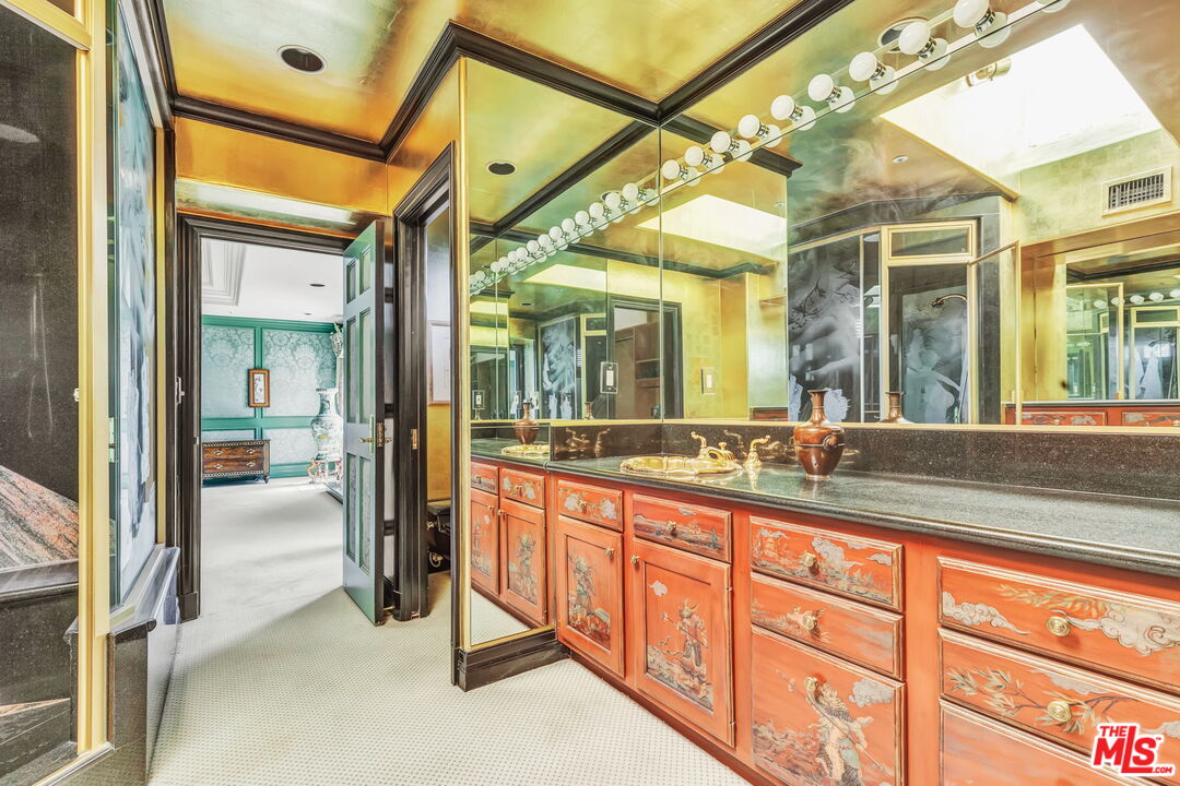 527 North Maple Drive Beverly Hills, CA 90210 - Photo 33 of 54 a bathroom with a granite countertop sink and a mirror
