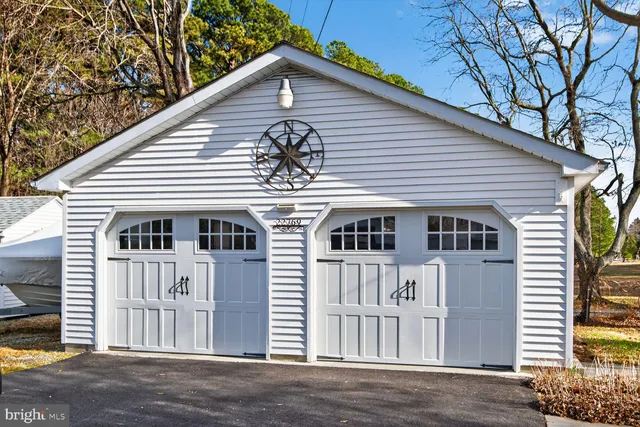 a backyard of a house with large trees and wooden fence
