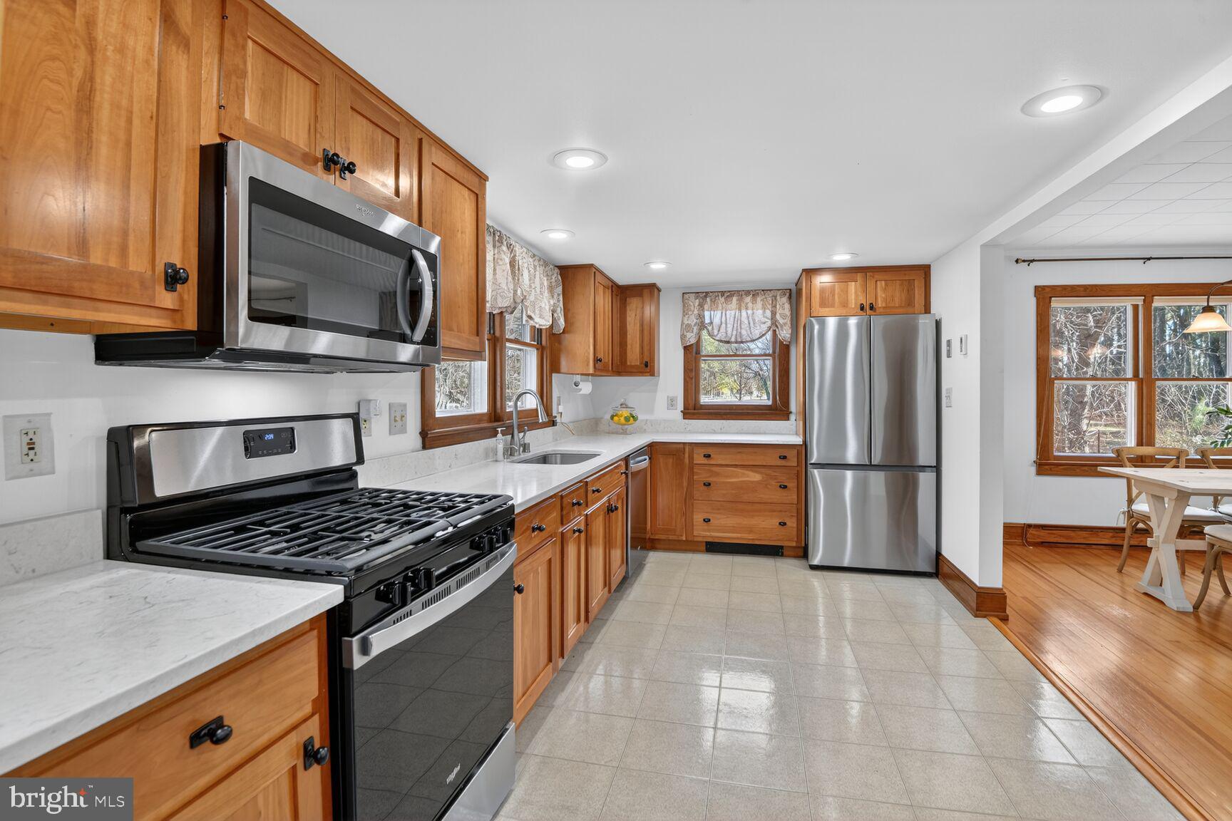 22769 Almost Neavitt Road Bozman, MD 21612 - Photo 23 of 44 a kitchen with stainless steel appliances a stove a sink a microwave a refrigerator and cabinets