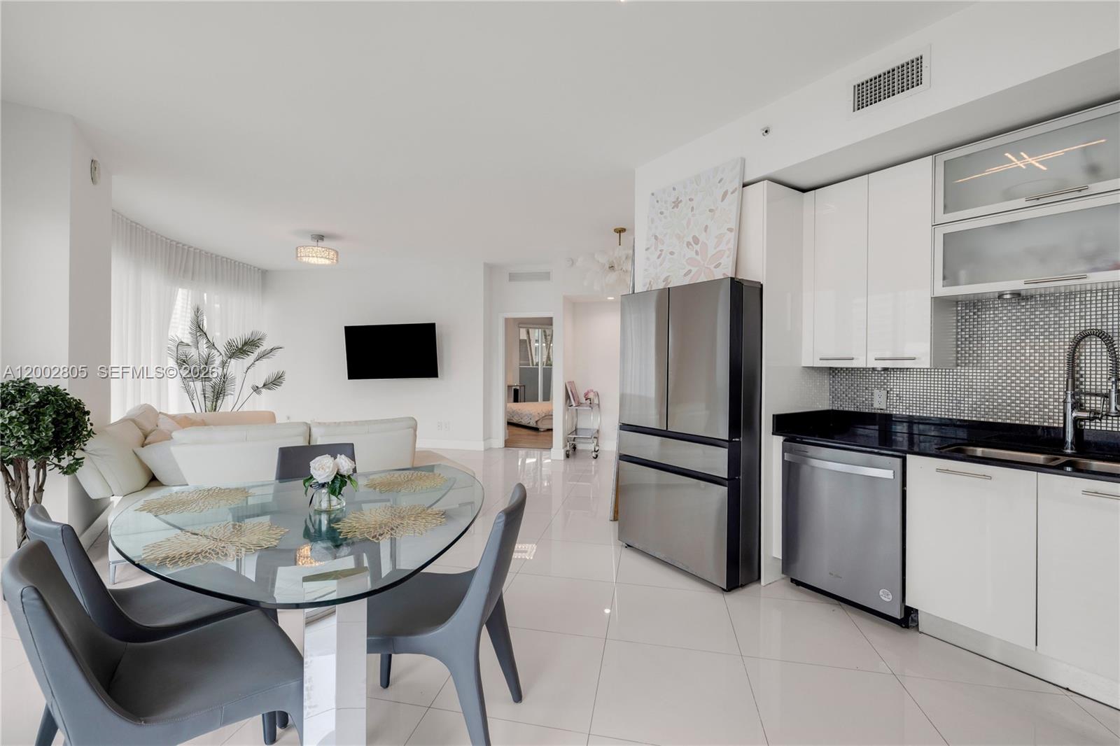 60 Southwest 13th Street, Unit 1124 Miami, FL 33130 - Photo 8 of 30 a kitchen with stainless steel appliances kitchen island granite countertop a kitchen island a stove a dining table and chairs